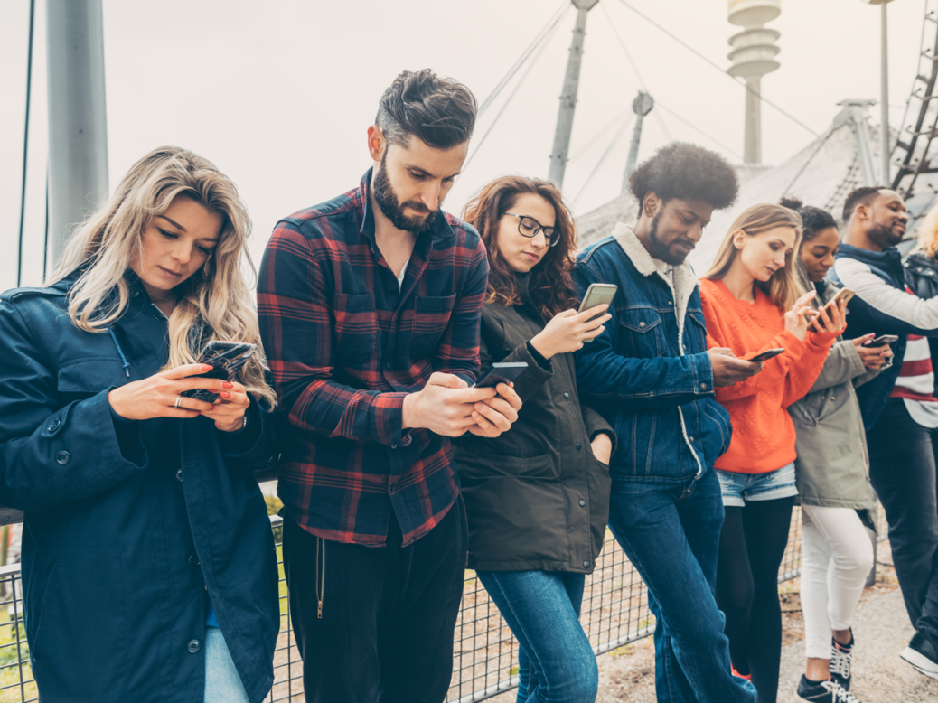 Young people looking at phones. Picture: Shutterstock