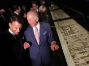 French President Emmanuel Macron and King Charles III laugh as they view a section of the Bayeux Tapestry Exhibition at the British Museum