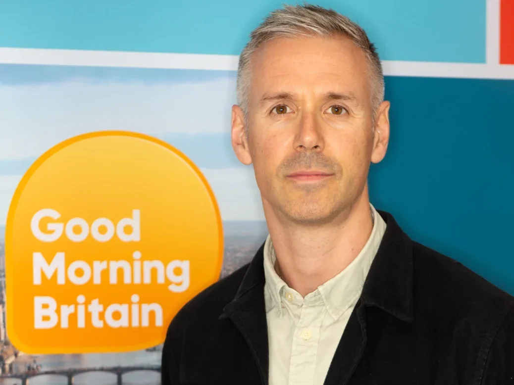 Newly-appointed Good Morning Britain editor Daniel Robinson. Headshot taken in front of GMB logo