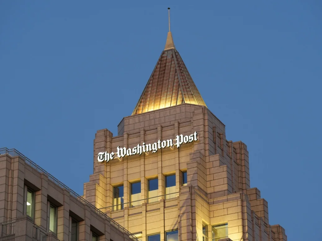The Washington Post building with its logo on top and night sky behind