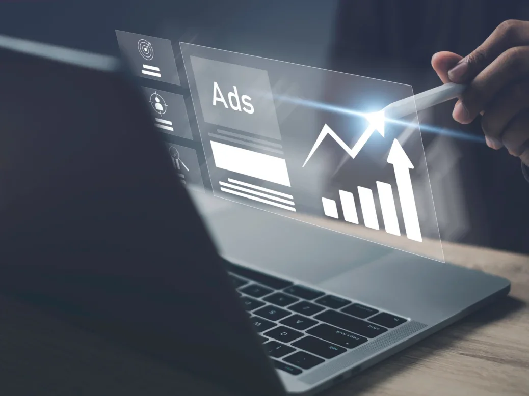 Open laptop with superimposed ad manager screen next to it with a chart showing growth