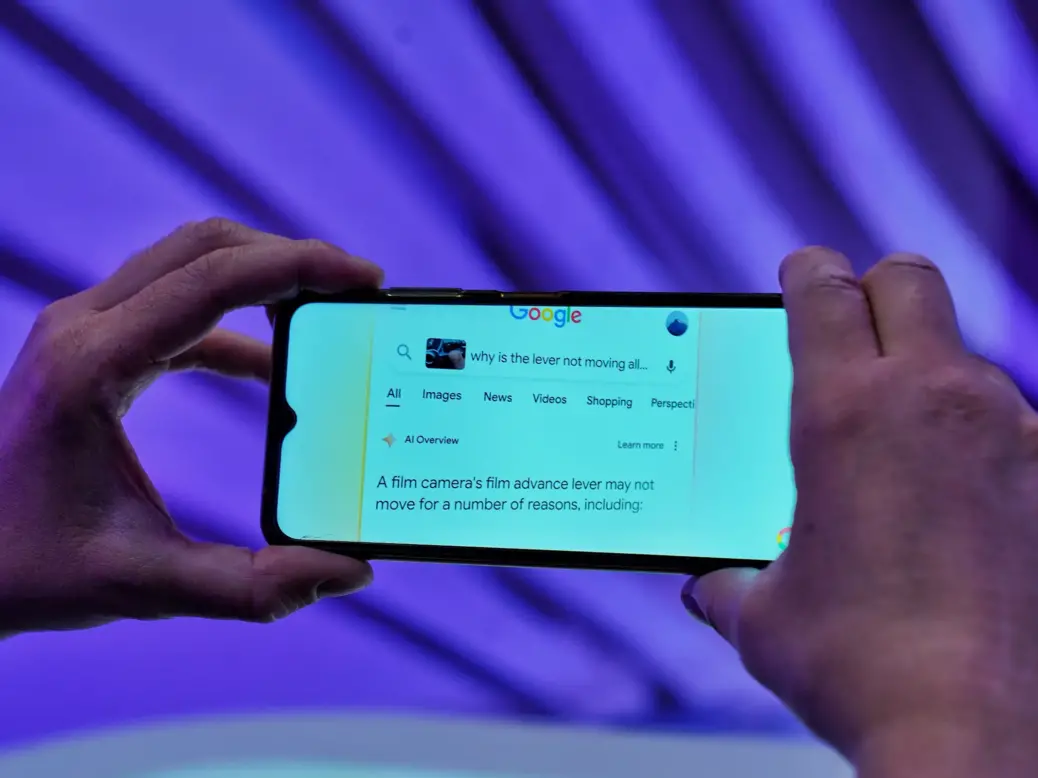 Google AI Overviews response on a mobile search. The search says: "Why is the lever not moving at all..." and the start of the AI response says: "A film camera's film advance lever may not move for a number of reasons, including:"