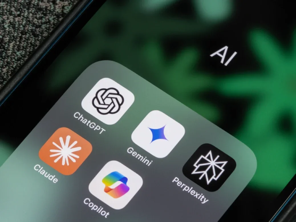 AI chatbots ChatGPT, Gemini, Microsoft Copilot, Claude, and Perplexity app icons are seen on the screen of an iPhone